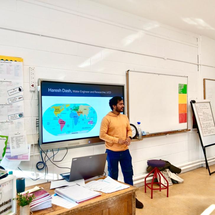 Photo of Haresh Dash presenting in front of a screen in a primary school classrooom